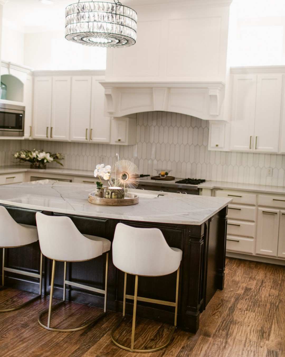 Large kitchen island with decorative brass hardware in an open-concept living space.