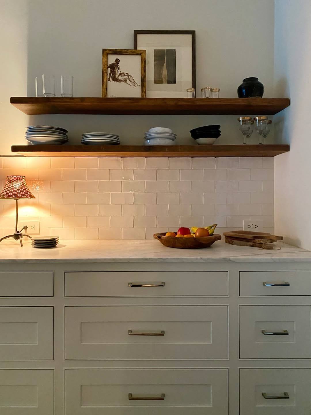 Elegant long bar pulls installed horizontally on sage green kitchen drawers.