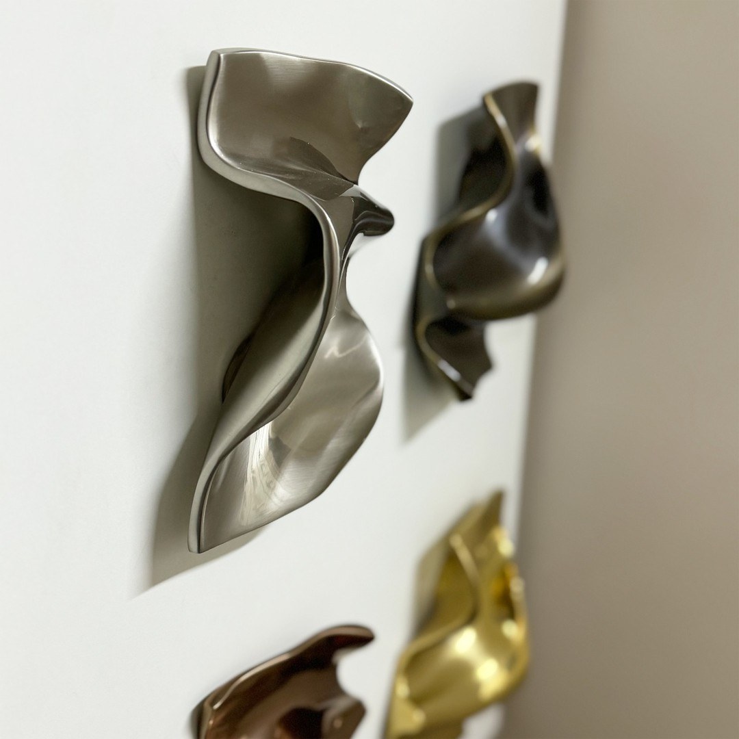 Unique artistic bronze cabinet pulls adding sculptural detail to kitchen cabinets.