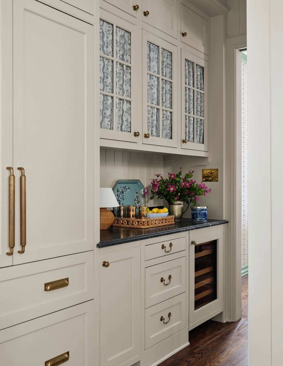 Clean white kitchen cabinets featuring a combination of brass knobs and drawer pulls.