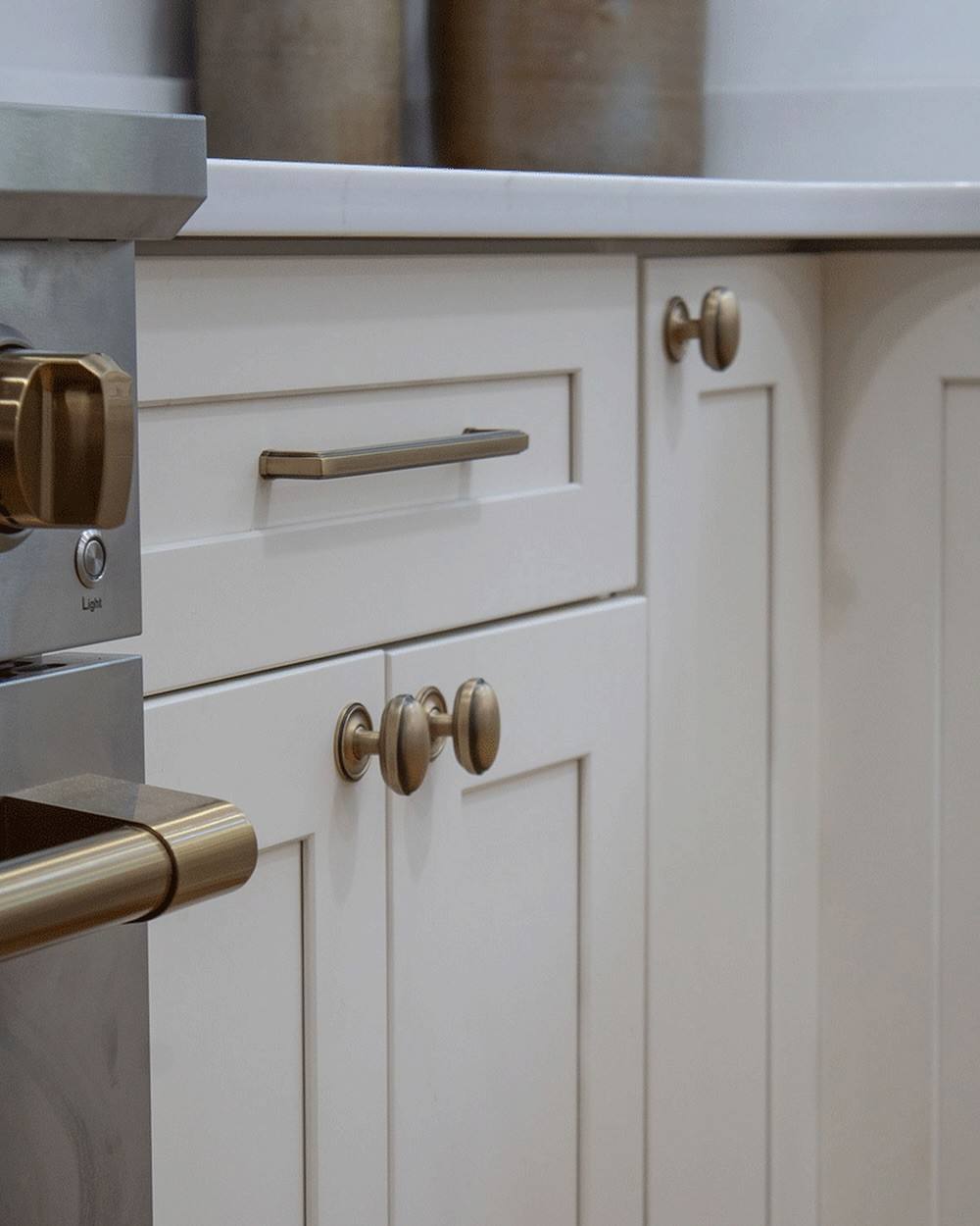Bright white kitchen cabinets accented with modern gold tone brass bar pulls.