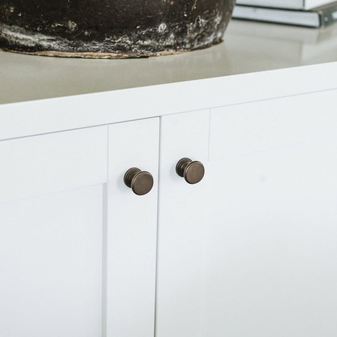 Traditional kitchen with white cabinets and classic round polished brass knobs.