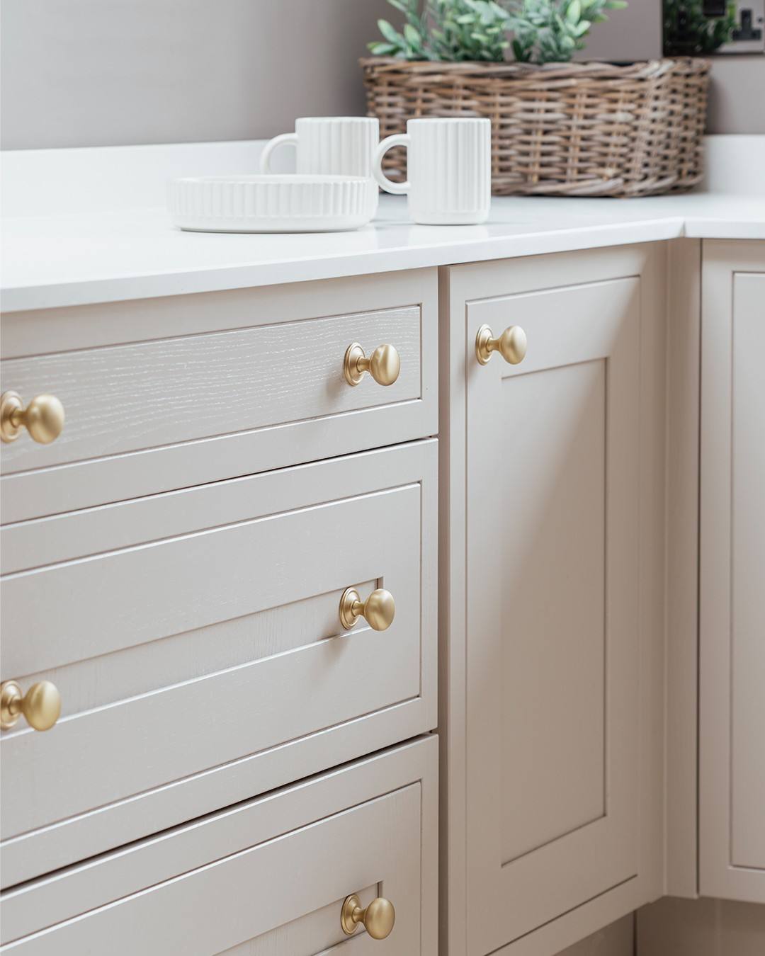 White kitchen cabinetry featuring uniform brass knobs on all drawer fronts.