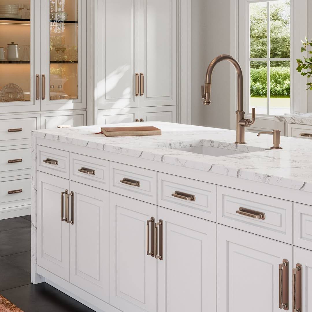 A white kitchen island featuring elegant brass hardware as a focal point.