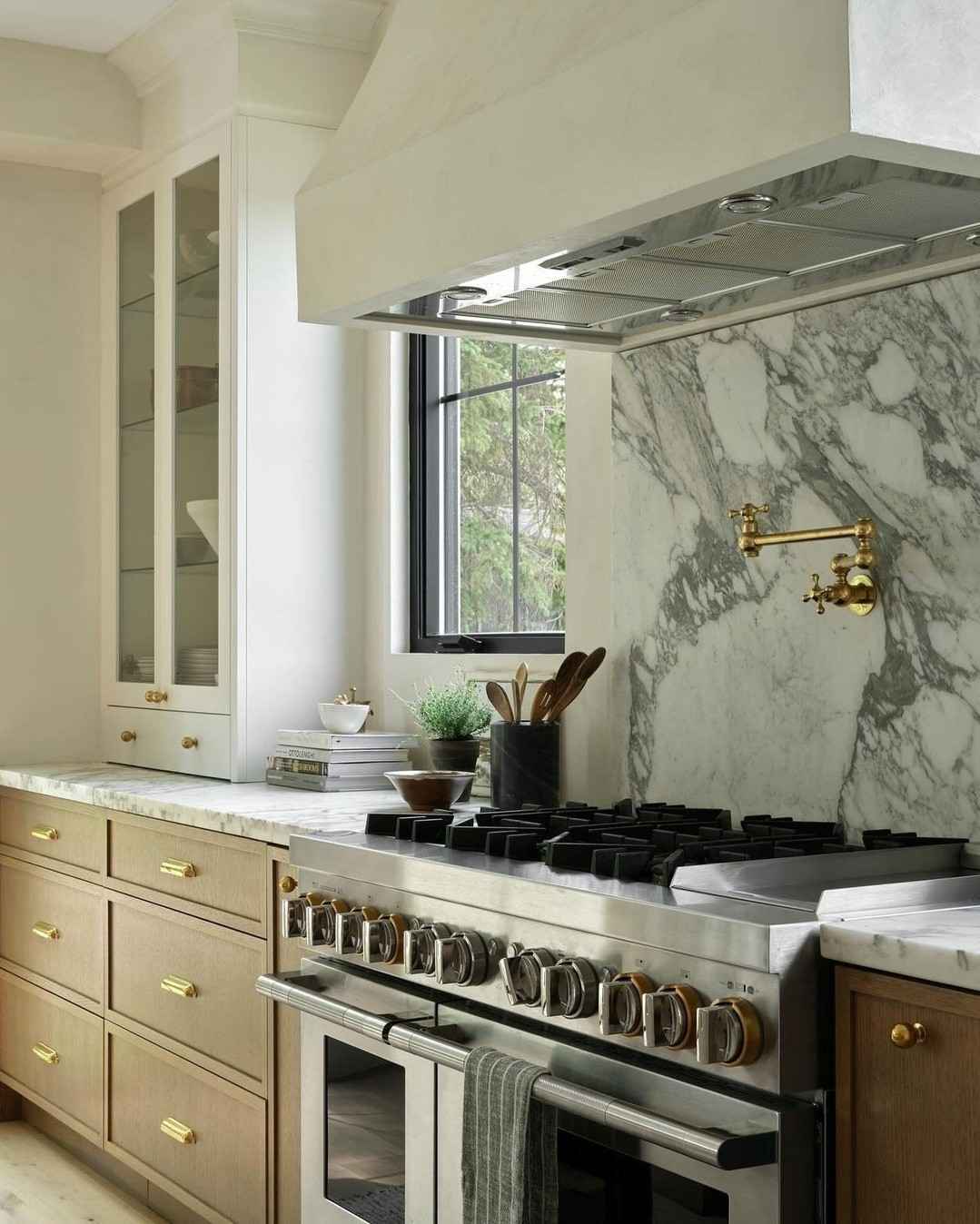 A bright airy white kitchen featuring stylish brass pulls on all doors.