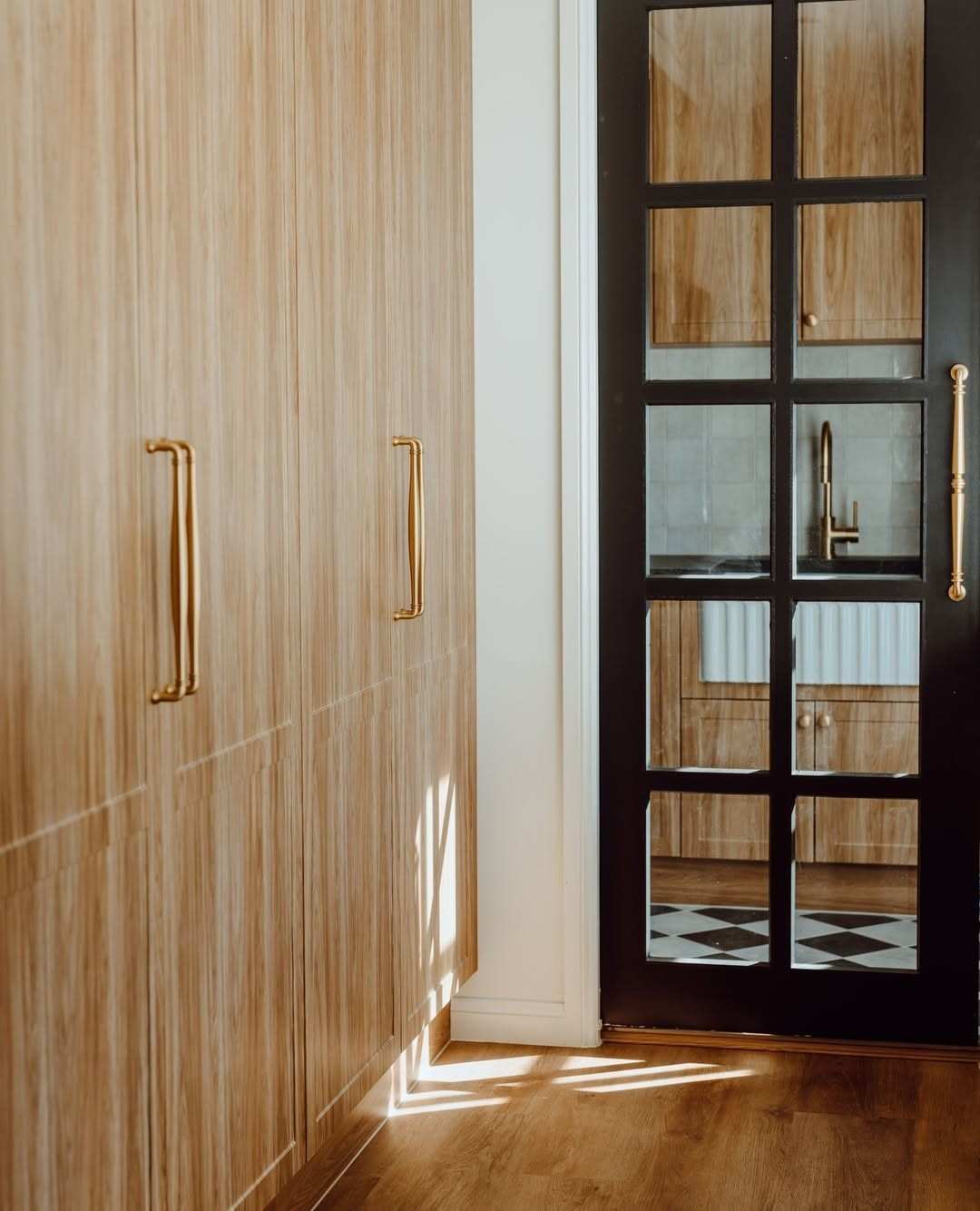 Natural wood grain kitchen cabinets paired with elegant brass pulls.