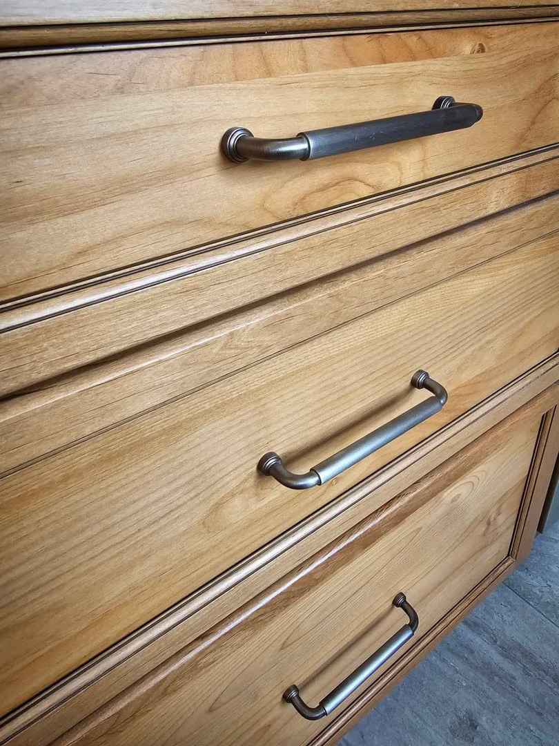 Rustic style wood kitchen drawers featuring classic brushed nickel cup pulls.