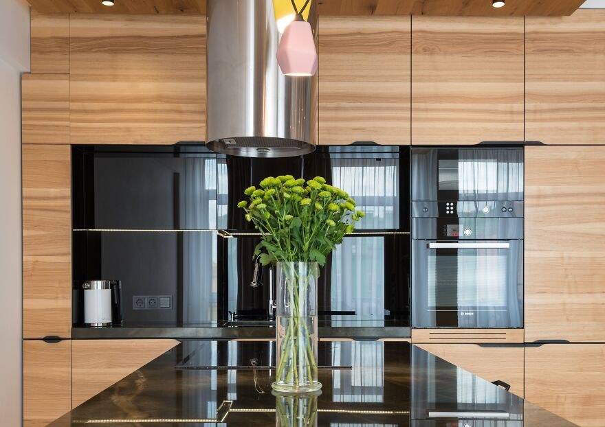 Kitchen with white perimeter cabinets and a bold navy blue island with leather stools.