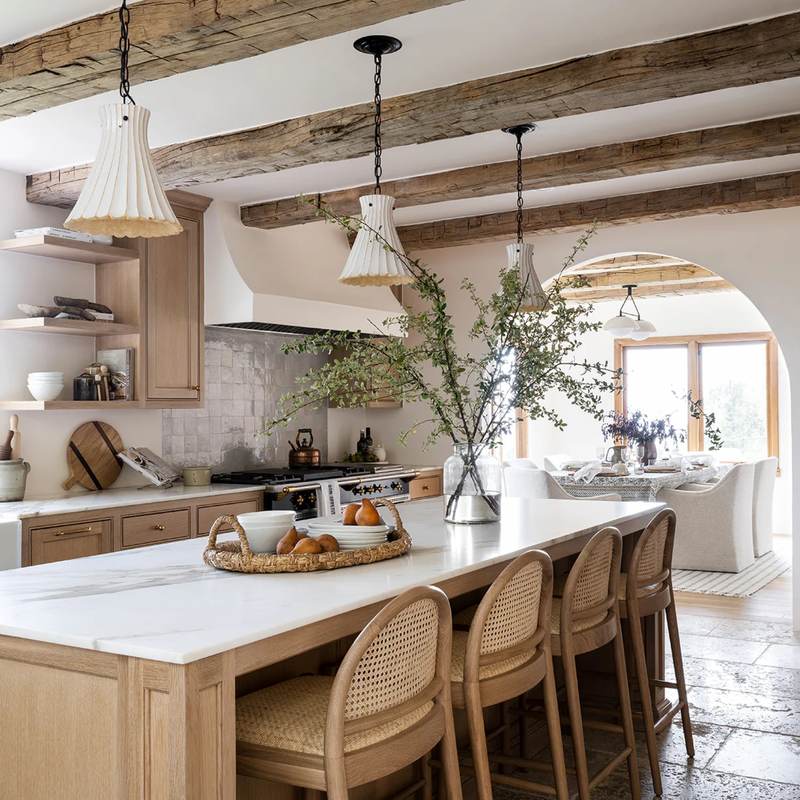 Kitchen with hand-painted Zellige tiles, white cabinets, and warm under-cabinet lighting.