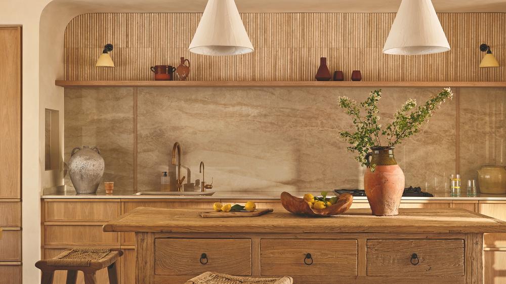 Modern kitchen interior featuring sleek matte black faucets and industrial hardware against white marble.