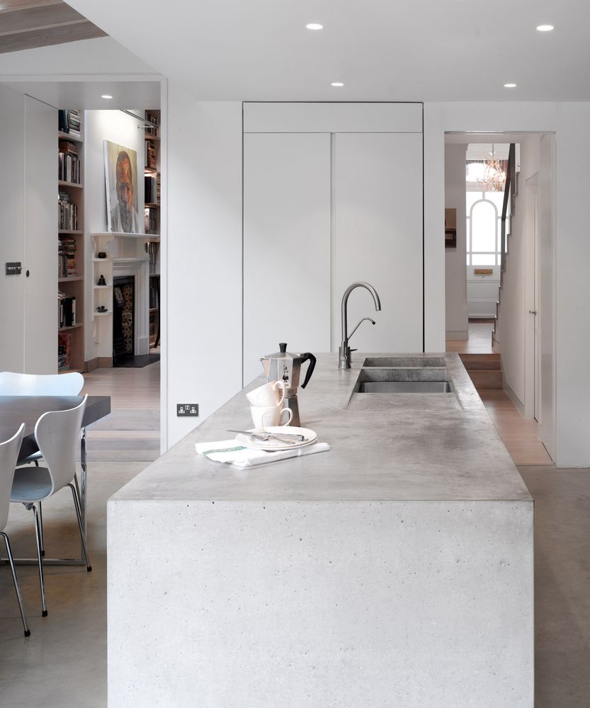 Kitchen space decorated with warm terracotta clay floor tiles and soft beige cabinetry accents.