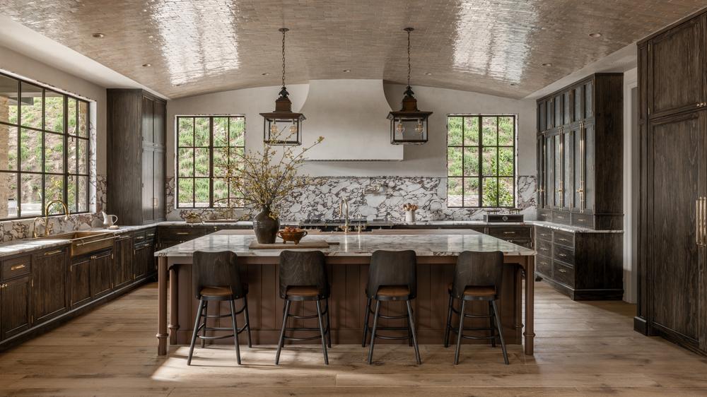 Large kitchen island with a dramatic marble waterfall countertop flowing to the floor.