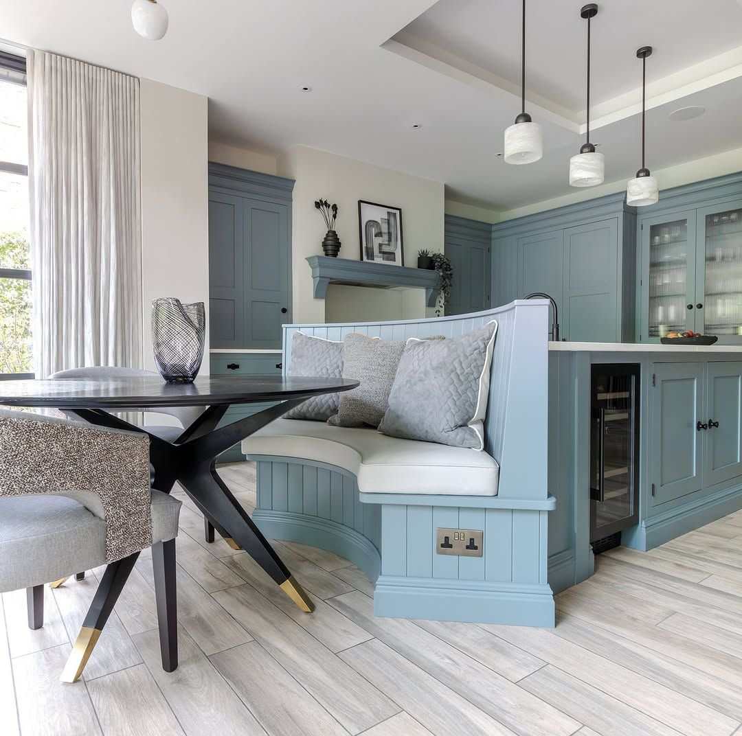 Japandi style kitchen featuring an oatmeal plaster island, slatted light wood accents, and beige ceramic decor.
