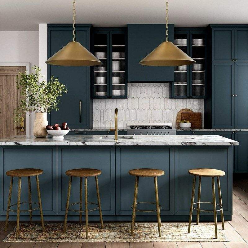 Multifunctional kitchen island featuring an attached upholstered dining banquette with a round oak table.