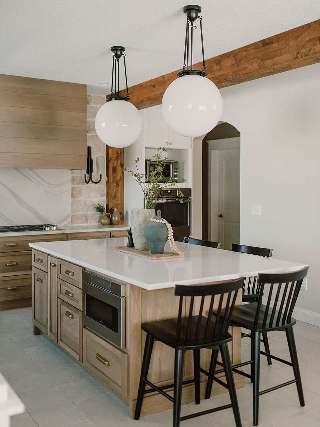 Vintage style sage green kitchen island with warm maple butcher block counter and antique brass hardware.