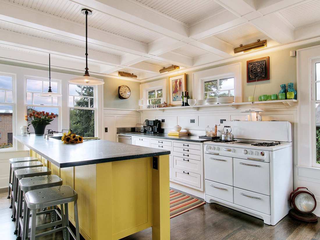 A soft blue kitchen island with beadboard paneling and a worn wooden top.