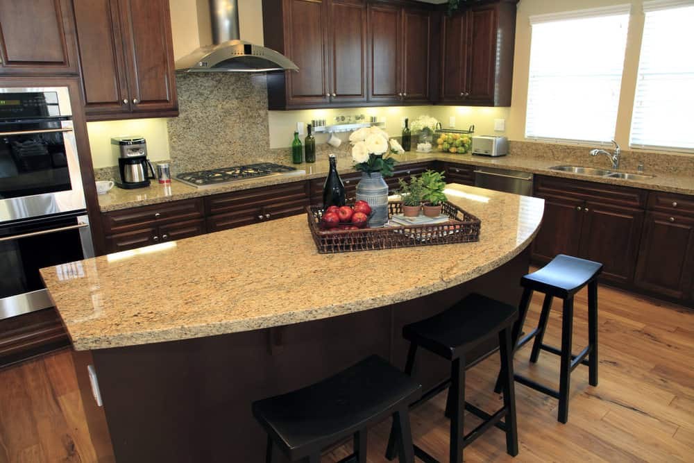 A modern kitchen island with built-in charging ports, touch-screen appliances, and hidden outlets.