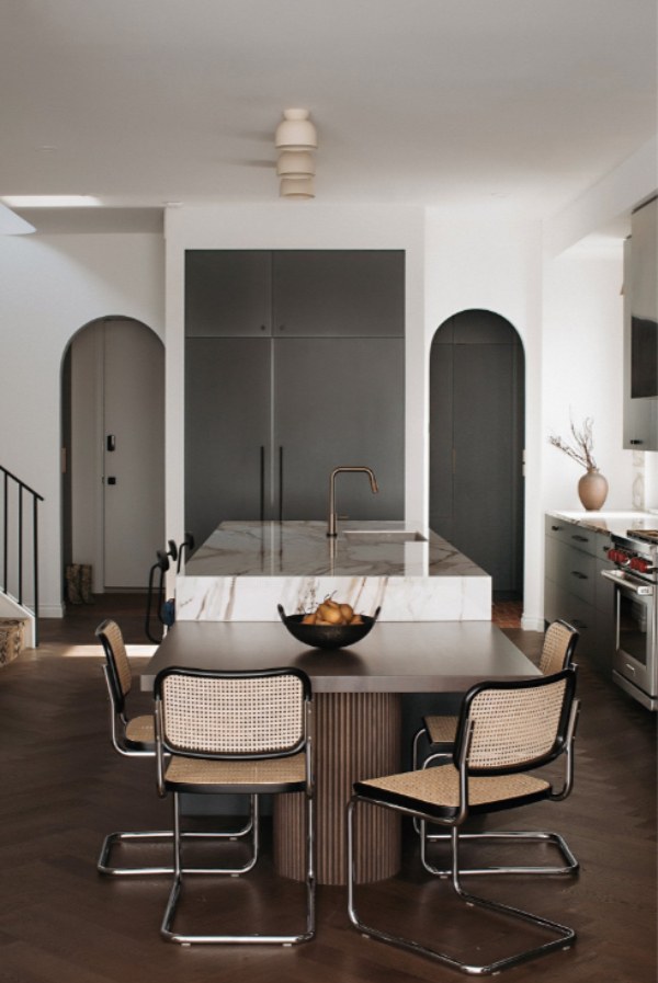 A kitchen island with an oversized butcher block top and open shelving underneath.