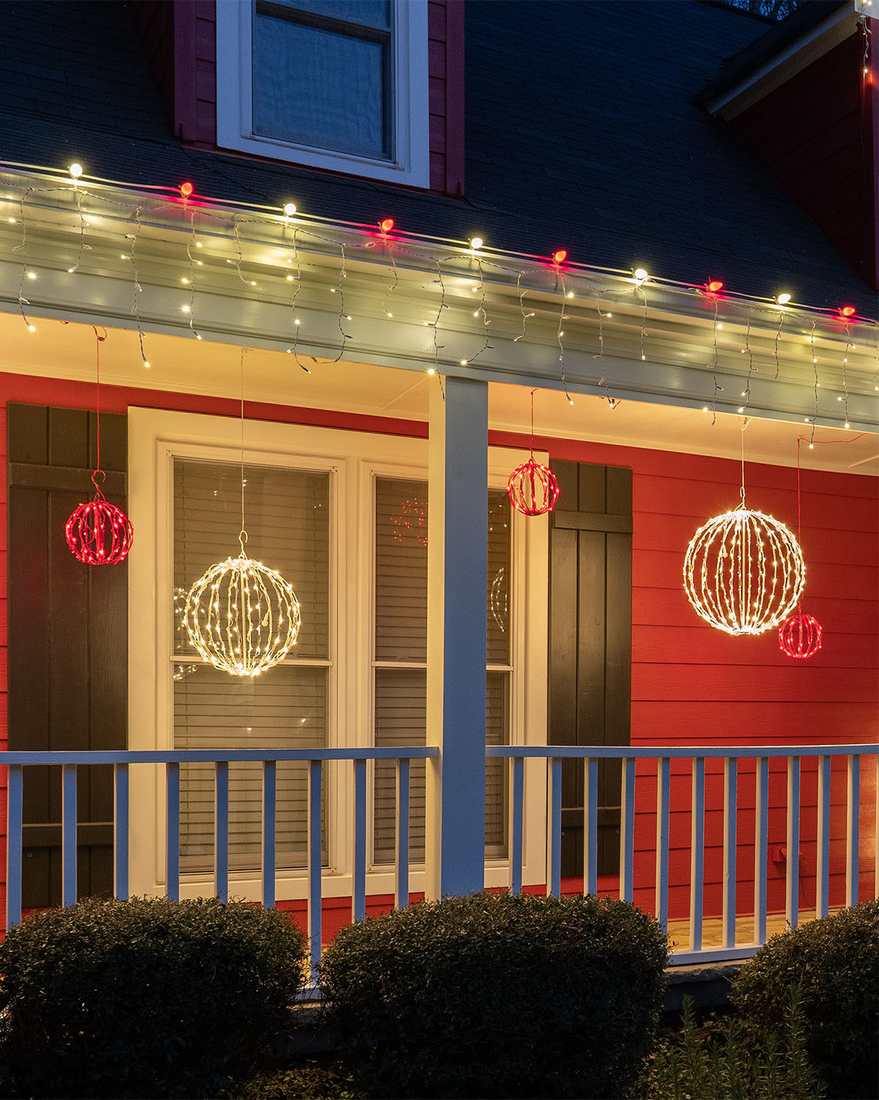 Glowing light spheres hanging from a covered porch as unique outdoor christmas decorations.