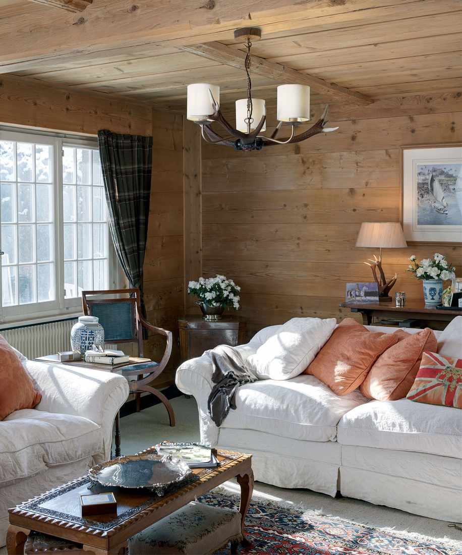 Elegant living room with silk pinch-pleat curtains, formal fireplace, antique furniture, crystal chandelier.