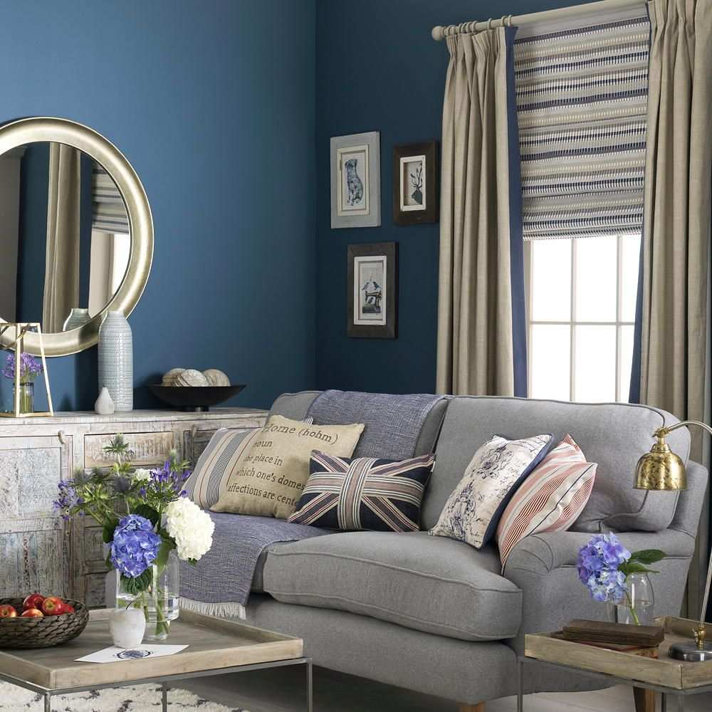 Boho chic living room with curtains featuring tassels, rattan chair, colorful rug, warm glowing lanterns.