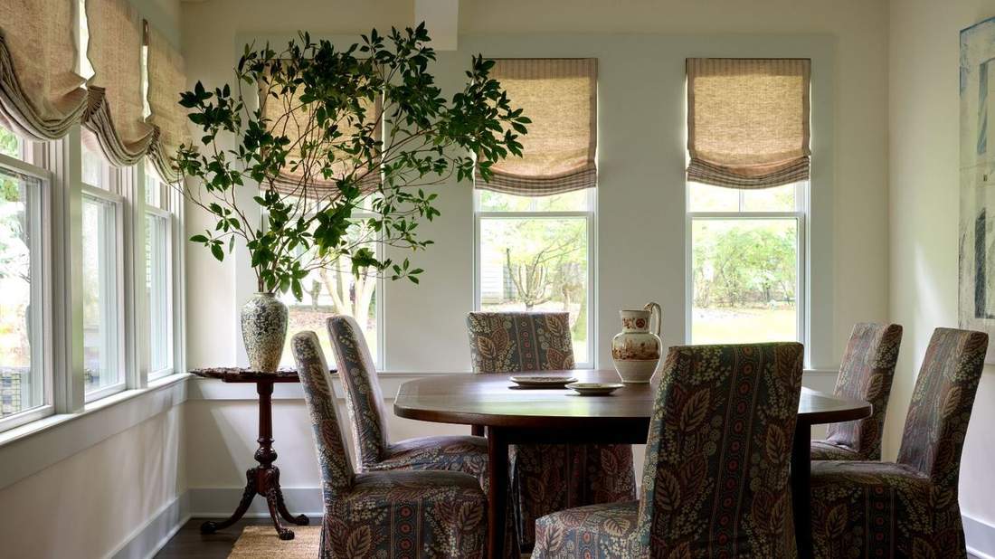Living room with two-toned curtains, beige and navy, minimalist sofa, gold hardware, bright spacious room.