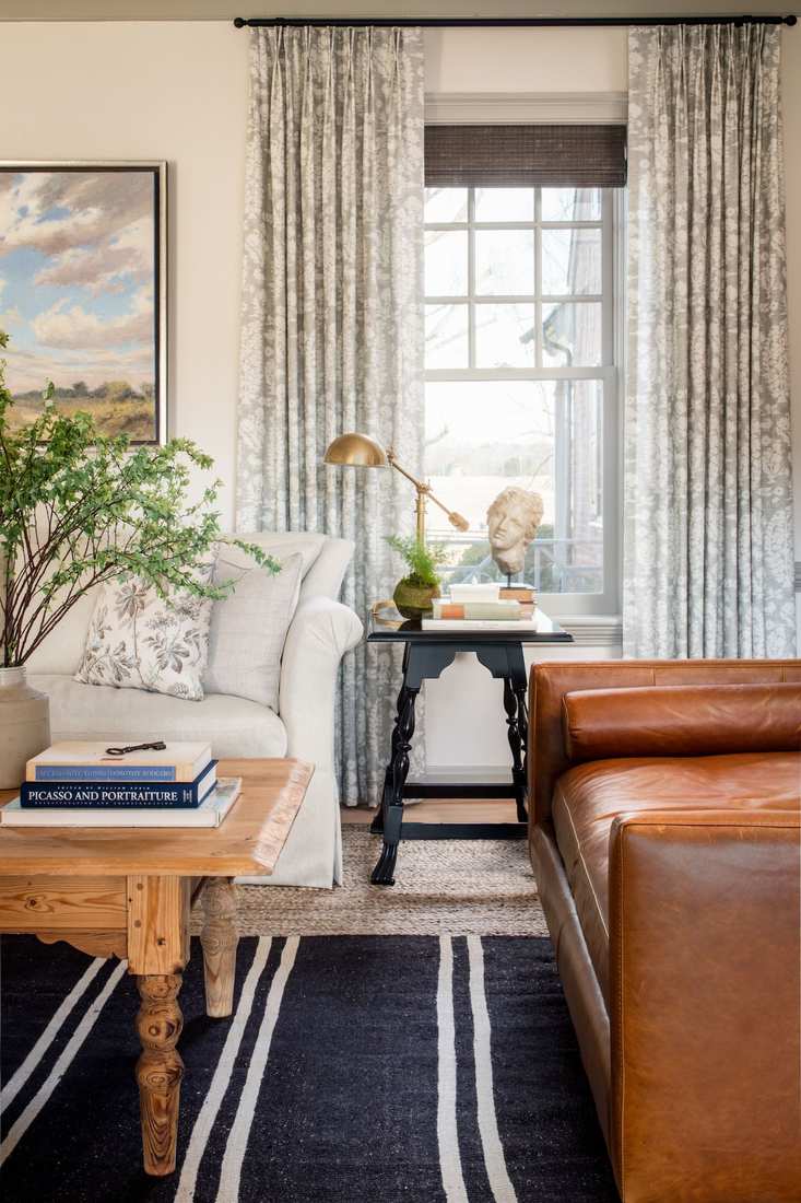 Rich emerald green velvet curtains hanging in a luxury formal living room setting.