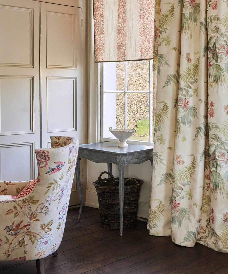 A decorative window valance over sheer curtains in a classic style living room.