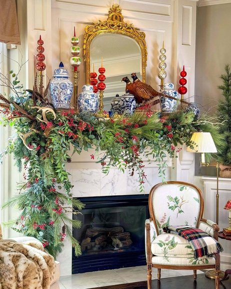 Fireplace mantel with chinoiserie pheasant figurines, gold garland, soft candlelight, polished wood.