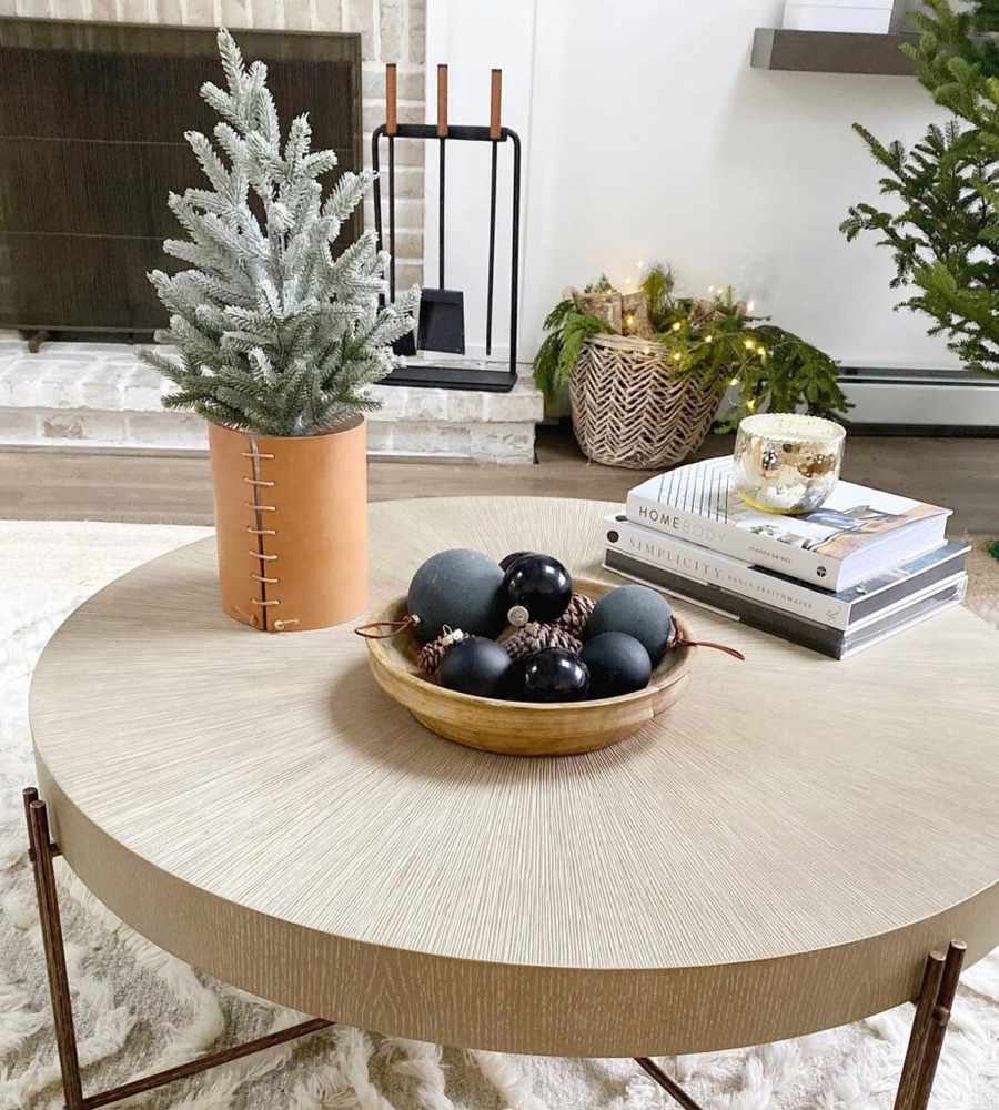 Modern Christmas coffee table styling featuring a cognac leather wrapped vase holding mini fir branches.