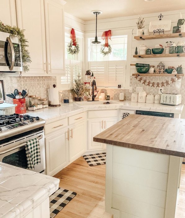 Small greenery wreaths attached to the back of white kitchen bar stools.