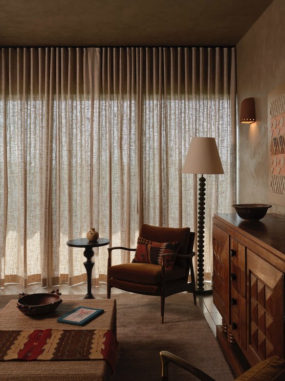 Clay colored walls walnut furniture and linen curtains for earthy organic vibe