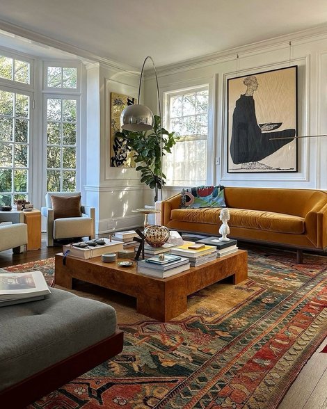 Mustard yellow armchair over vintage persian rug with modern furniture mix