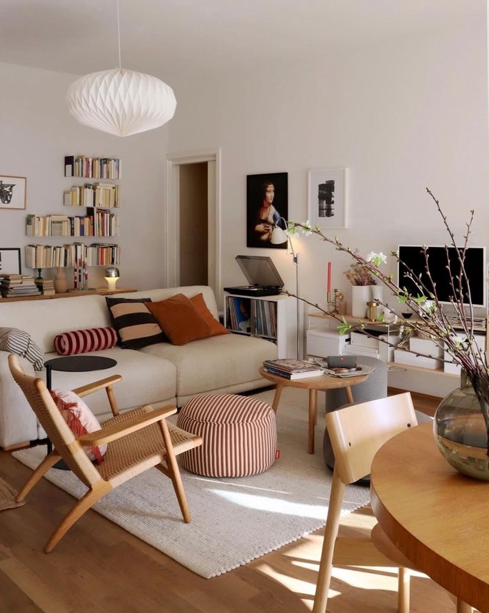 Cream walls light wood furniture and rust accent pillows scandinavian style