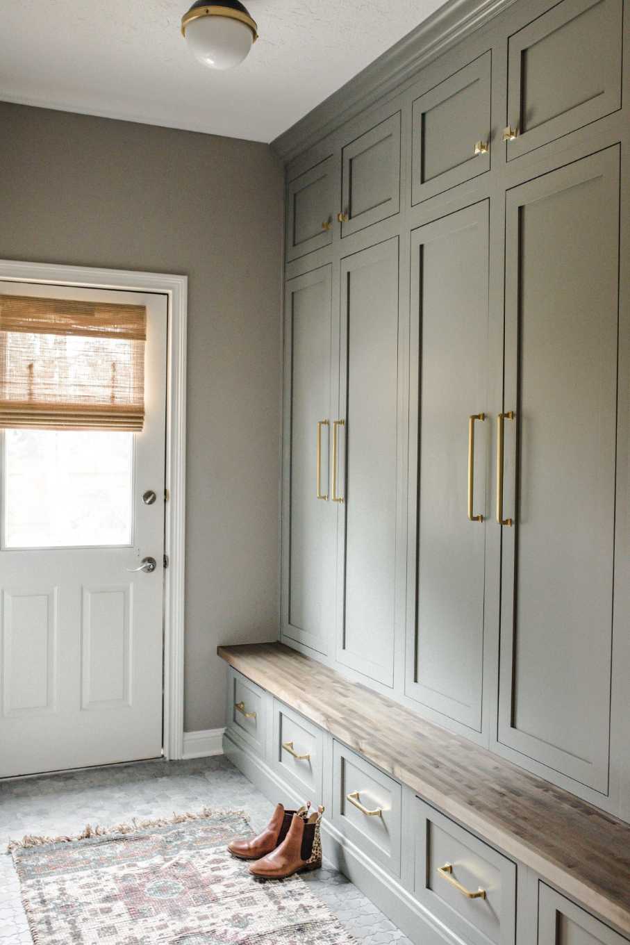 Mudroom with floor‑to‑ceiling grey wardrobe closets, glass front, LED interior lighting, soft carpet runner