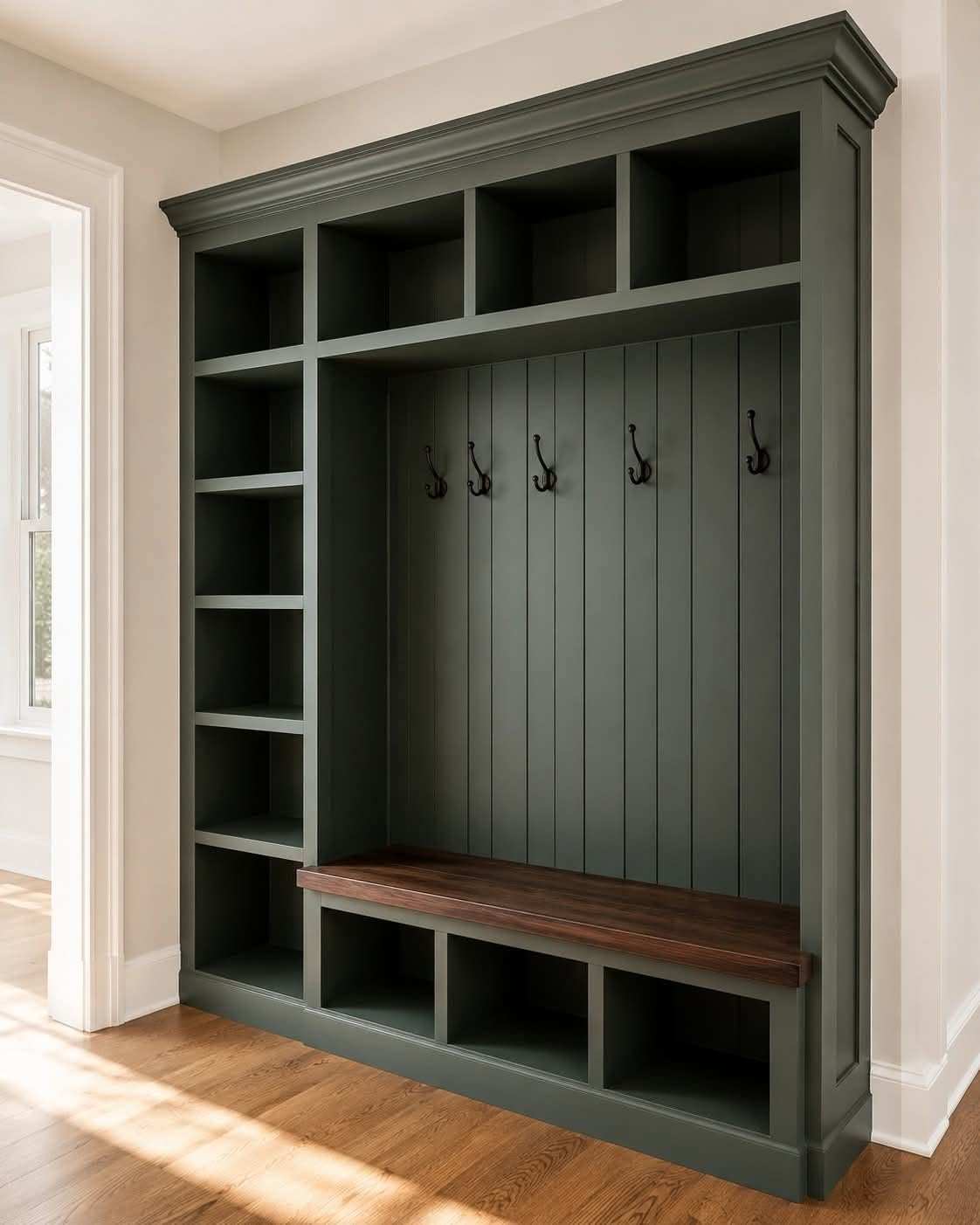 Mudroom with hunter green hall tree, reclaimed wood branches, brass coat hooks, warm lighting