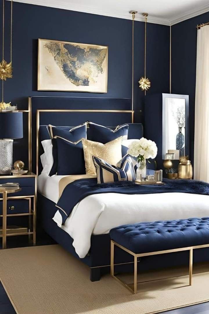Navy bedroom showcasing a gold‑framed bed, tufted bench, and coordinated lighting.