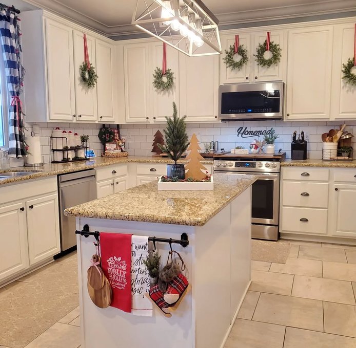 Large rustic wreath with pinecones and berries on the kitchen cabinet door.