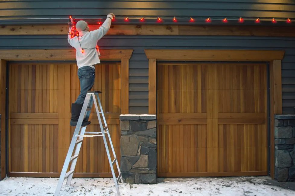 Close up of damage free light clip attaching warm string light to wooden window casing