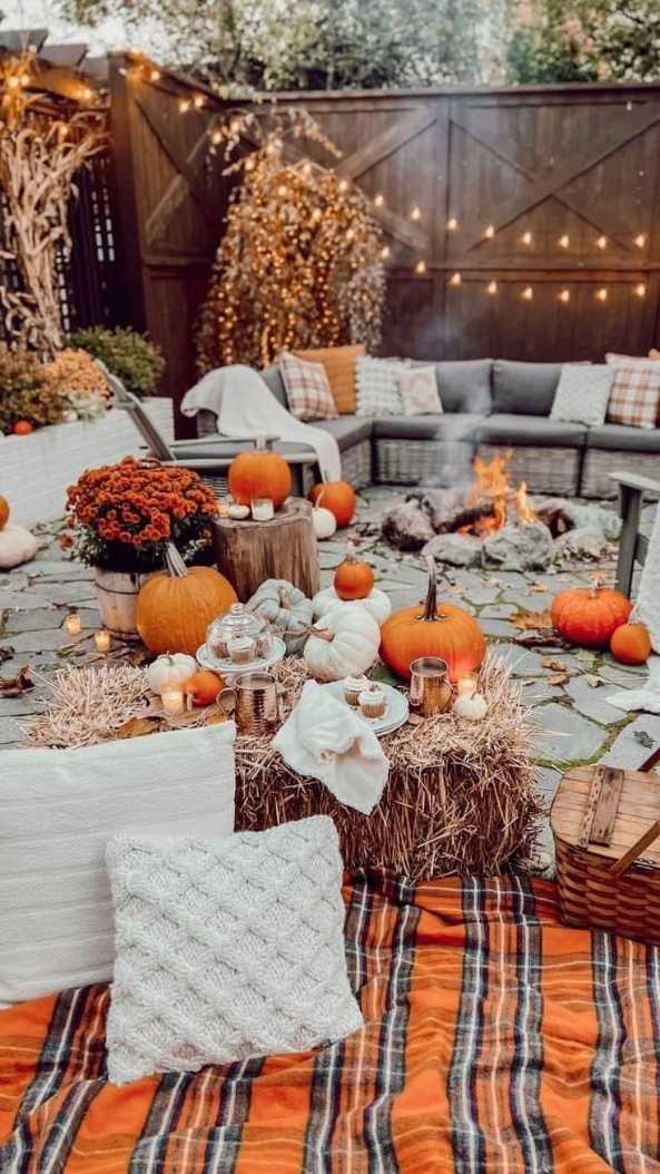 Fire pit surrounded by hay bale seats, cozy blankets, ambient firelight, natural outdoor setting