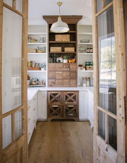Tiered bamboo spice rack inside a pantry, matte black labels, wood shelves, warm under-shelf light.