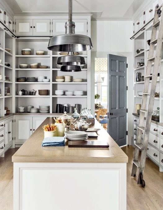 Kitchen pantry with pull-out wire drawers, matte white finish, organized dry goods, ambient lighting.