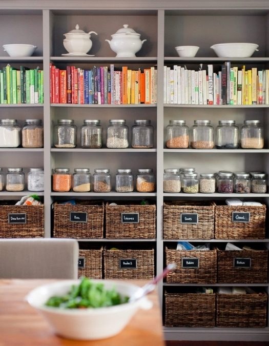 Pantry door interior with mounted wire racks, jars, and spices, white finish, bright kitchen light.
