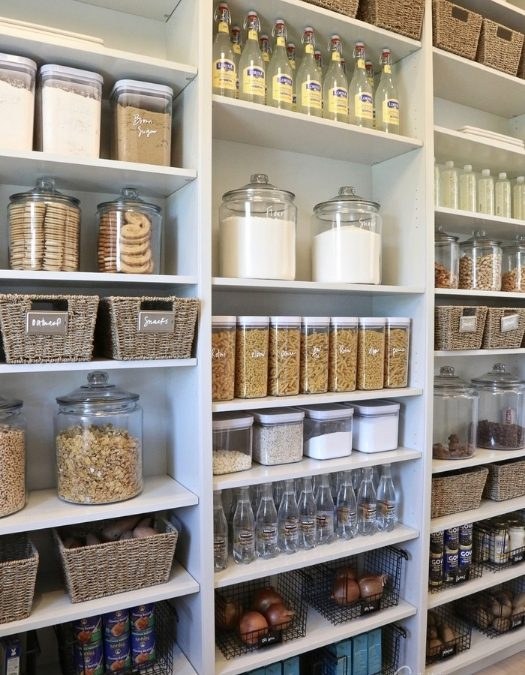All-white pantry with matching containers, white labels, clean lines, bright soft lighting.