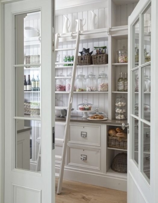Pantry shelves with industrial-style wire mesh bins, black metal, wood shelving, warm lighting.