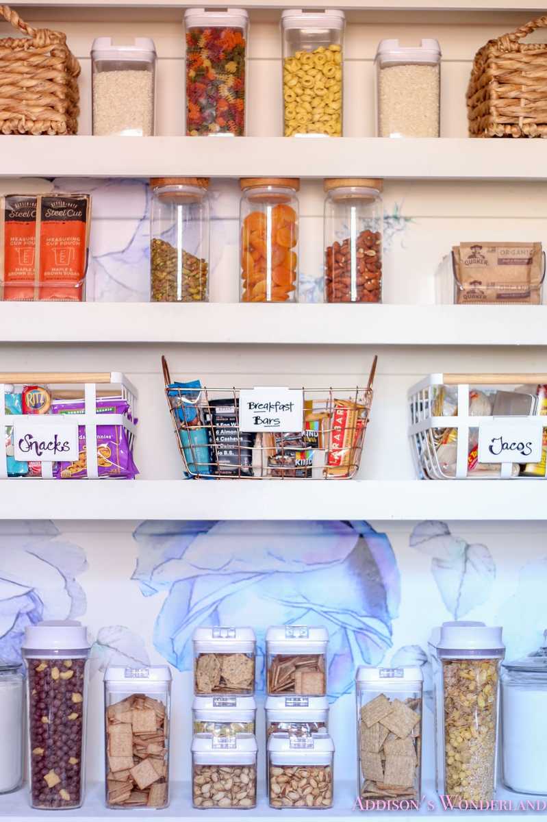 Pantry wall with white pegboard, wooden hooks, organized kitchen tools, warm lighting.