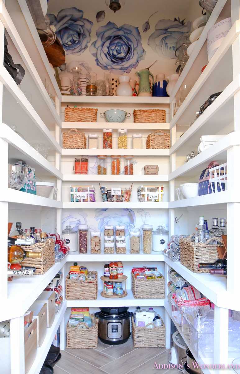 Glass jars with gold lids, white shelf, gold shelf trim, warm glowing interior lights.
