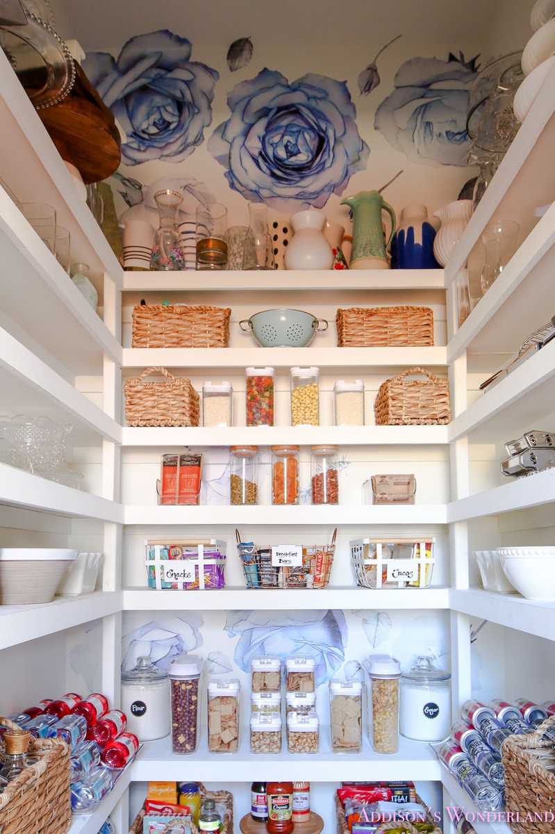 Pantry shelf with stackable plastic trays, clear design, organized snacks, bright LED lighting.