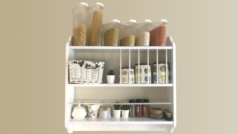 Pantry organization ideas using natural woven wicker baskets on pull-out wooden drawers.