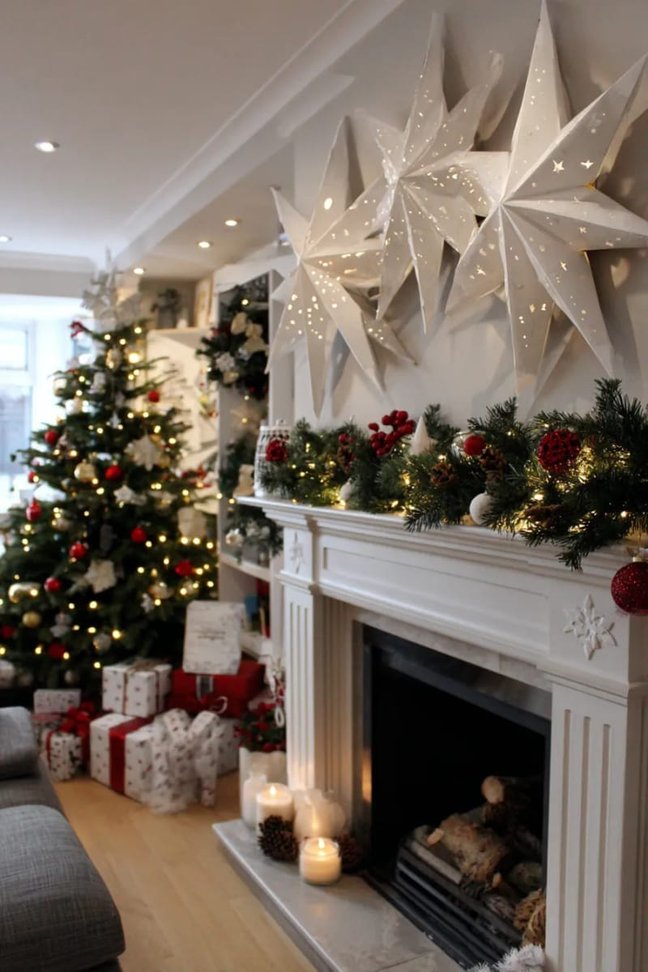 Rustic wood mantel with hanging paper stars, warm string lights, and a simple pinecone arrangement.